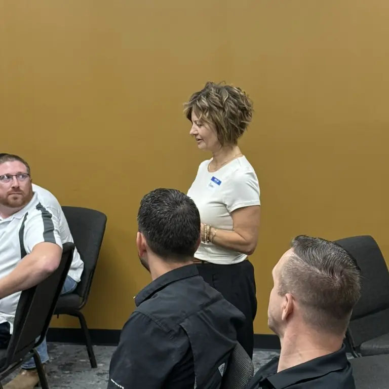 A woman speaking to members seated around her at a twelve gathering
